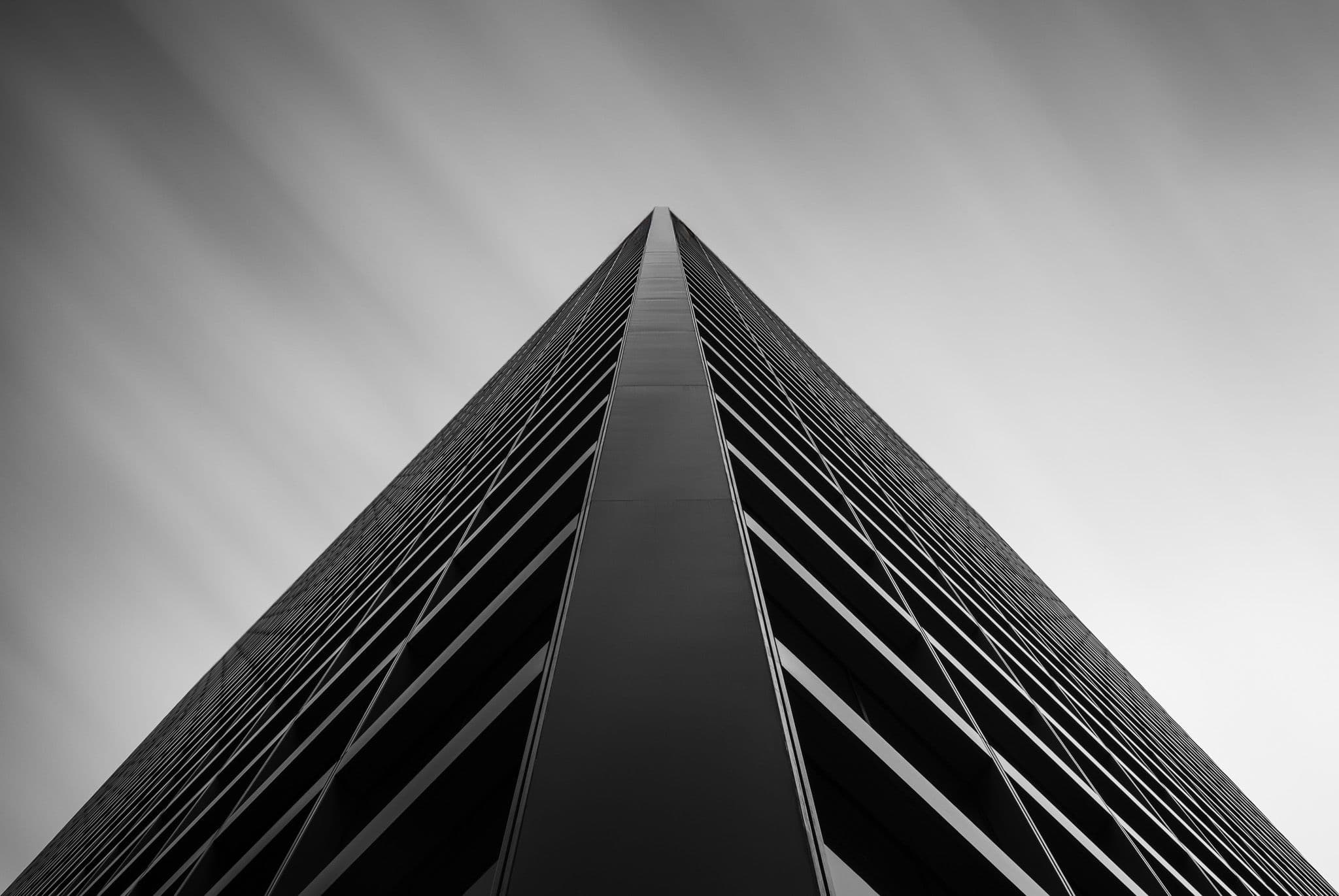 Building with streaking clouds in the background, black and white